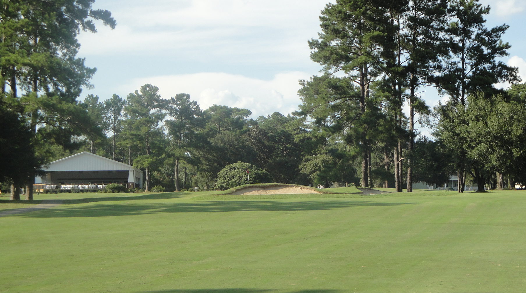 A fairway at Summerville Country Club lined with pines.